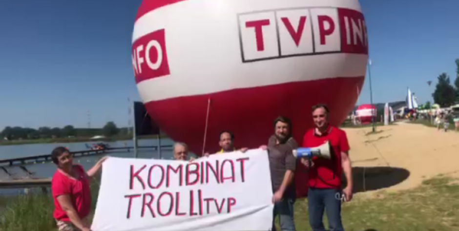 Kilka osób rozpostarło baner