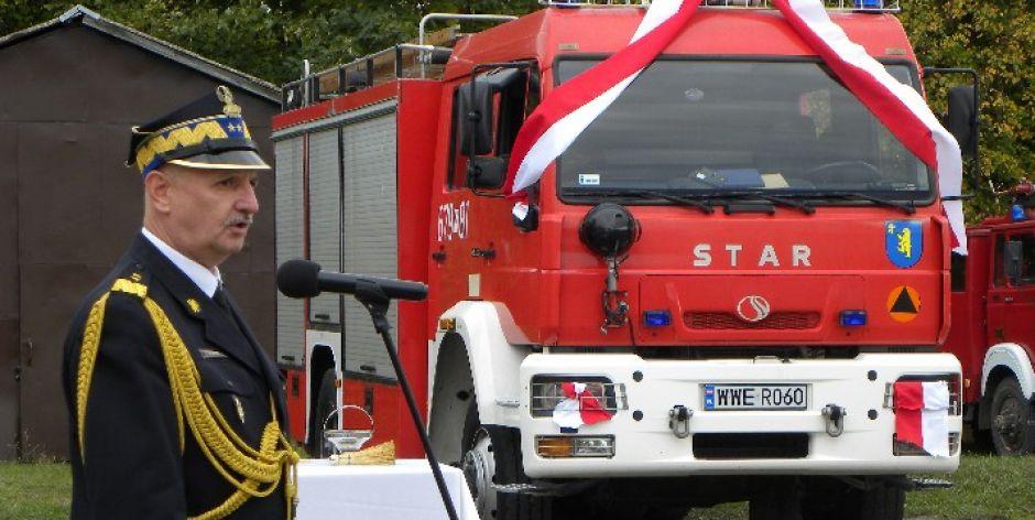 Komendant główny PSP gen. bryg. Leszek Suski na tle wozu bojowego, który dostali strażacy z Wierzbna.  fot. sej