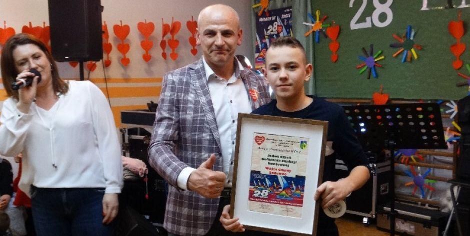 Wójt Waldemar Cyran z Dawidem Ogonowskim. Z lewej prowadząca licytację Monika Tyszka z zespołu 