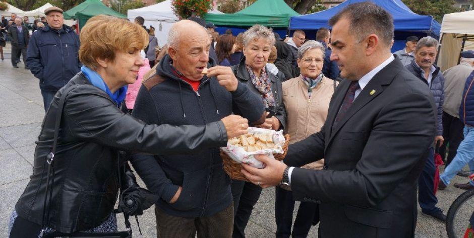 Burmistrz Paweł Marchela dzieli się chlebem. 