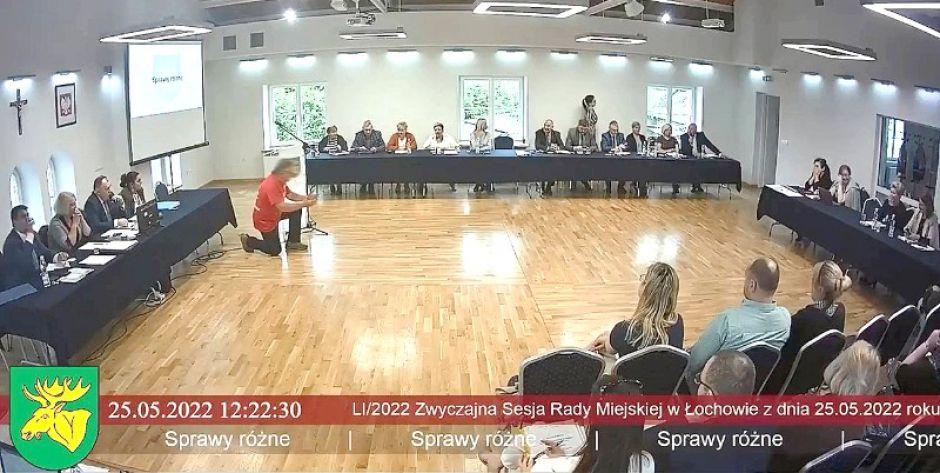 Mieszkaniec na klęczkach... (stopklatka z transmisji sesji Rady Miejskiej w Łochowie) - fot. stopklatka z transmisji sesji Rady Miejskiej w Łochowie