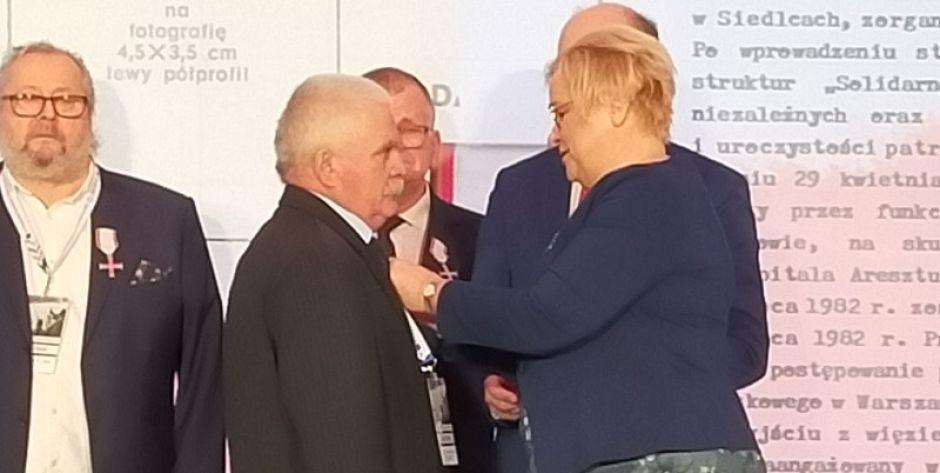 Szefowa Kancelarii Prezydent Grażyna Ignaczak-Bandych wręcza odznaczenie Krzysztofowi Szymańskiemu.  fot. Eliza Maciopa - fot. .