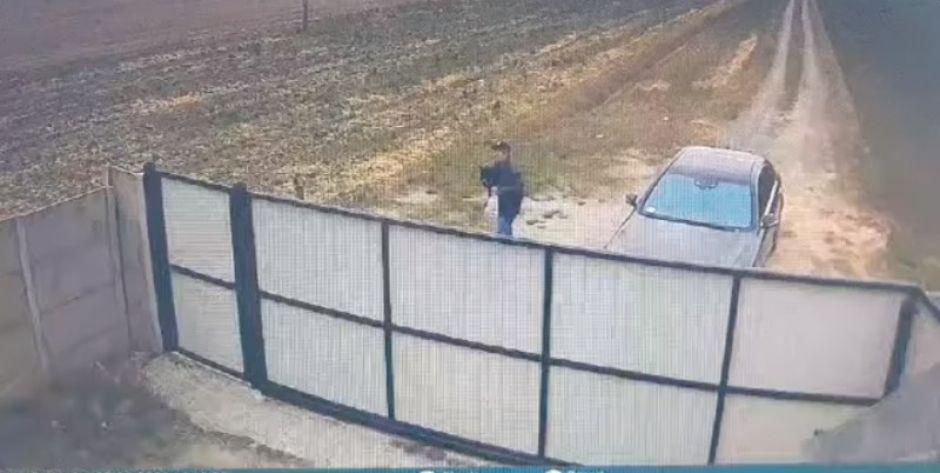 Kadr z nagrania, na którym mieszkaniec gminy Stanin przerzuca zwierzę przez ogrodzenie. (Schronisko dla psów 