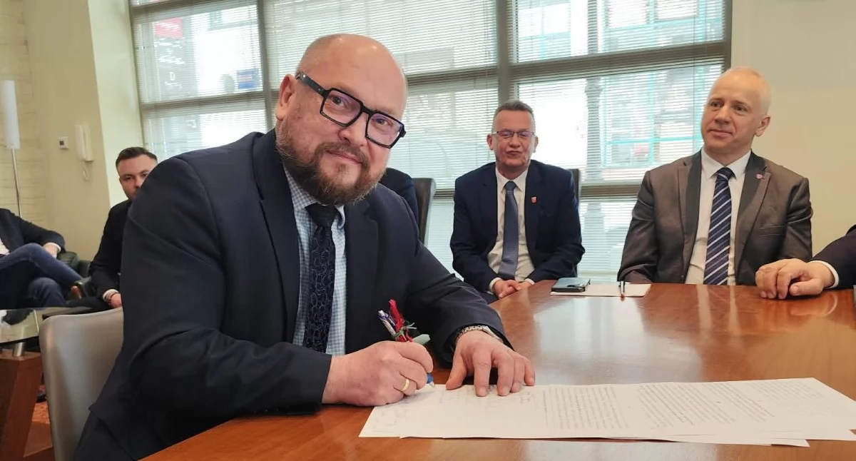 Prezes Paweł Mazurkiewicz podpisuje umowę dotyczącą przejęcia działki w Woli Suchożebrskiej. Fot. Arch.
