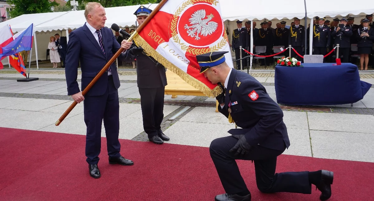 Sekretarz stanu w MSWiA Czesław Mroczek wręcza komendantowi PSP w Węgrowie bryg. Mateuszowi Bieniakowi nowy sztandar jednostki.  fot. sej