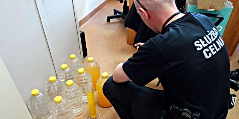 Funkcjonariusz Służby Celnej z częścią zarekwirowanego alkoholu. Fot. A. Maliszewska - fot. 