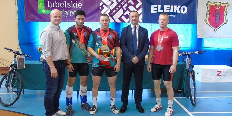 Mistrzowie ciężarów. Z lewej stoi Robert Dołęga, trener kadry narodowej w podnoszeniu ciężarów, drugi z prawej, miedzy zawodnikami - Grzegorz Osial. Fot. Facebook - fot. Fot. Arch. Facebook