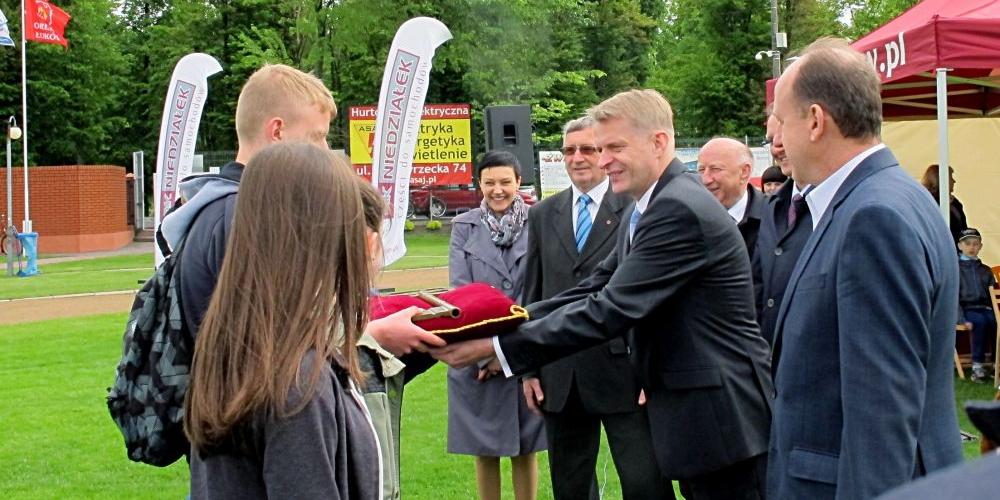 Burmistrz miasta, Dariusz Szustek w asyście łukowskich samorządowców przekazuje reprezentacji młodzieży klucz do symbolicznych bram miasta. Fot. PGL - fot. 