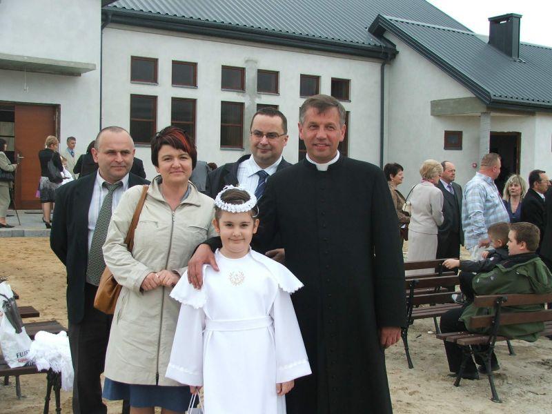Proboszcz parafii pw. bł Męczenników Podlaskich, ks. Jacek Szostakiewicz odprawił w minioną niedzielę mszę w murach nowej kaplicy, udzielając I Komunii Świętej 61 dzieciom. Na zdjęciu ksiądz proboszcz z Karolinką Jakubiak oraz jej rodzicami - Barbarą i Pa - fot. 