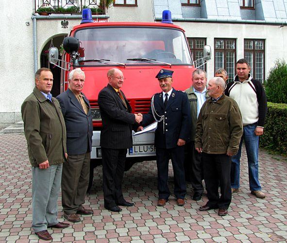 Przedstawiciele jednostki Ochotniczej Straży Pożarnej w Burcu wraz z wójtem gminy Wojcieszków przed Urzędem Gminy – uroczysta chwila przekazania nowego samochodu bojowego. Fot. Arch. UG w Wojcieszkowie - fot. 