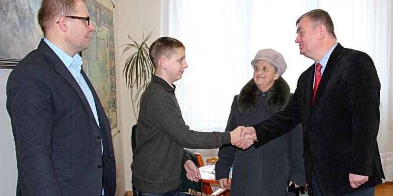 Wicestarosta łukowski, Krzysztof Tymoszuk wręcza nagrodę za zwycięstwo w konkursie Przemkowi Białeckiemu, który na spotkanie do Starostwa przyszedł ze swoją babcią. Pierwszy z lewej - Roman Bocian, naczelnik Wydziału Promocji, Rozwoju i Spraw Społecznych. - fot. 