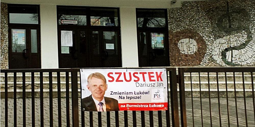 Baner wyborczy kandydującego na burmistrza Łukowa Dariusza Szustka wisi na parkanie budynku IV LO i Medycznego Studium Zawodowego. Fot. (Ł) - fot. 