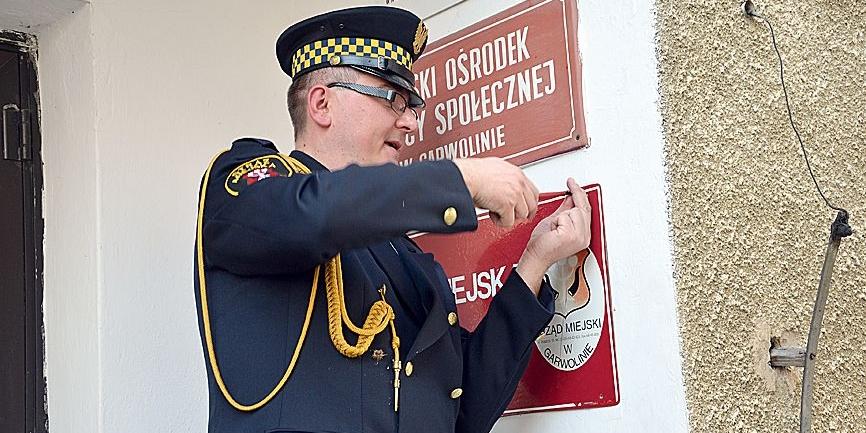 Marzec 2014. Tomasz Majczyna, odkręcając tablicę, symbolicznie zakończył funkcjonowanie Straży Miejskiej w Garwolinie. Fot. łk - fot. 