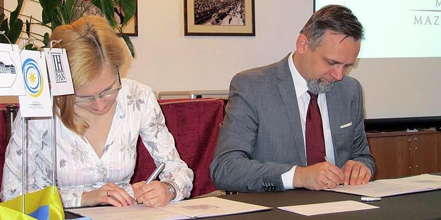 Burmistrz Marcin Jakubowski podpisuje umowę z Anną Saliną z Instytutu Historycznego PAN. Fot. B. Nowotniak - fot. 