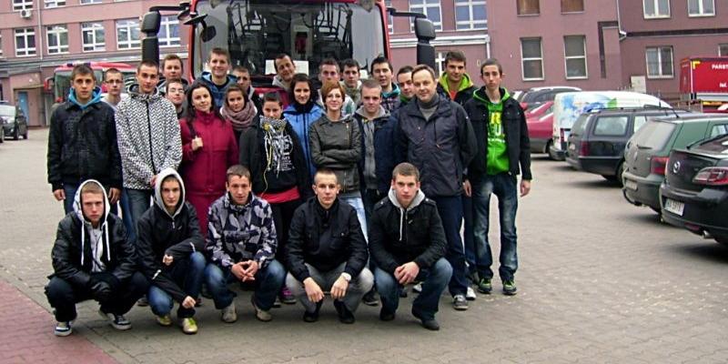 Uczniowie klas pożarniczych z Zespołu Szkół w Radoryżu Smolanym podczas pobytu na terenie Szkoły Głównej Służby Pożarniczej w Warszawie. W tle drabina pożarnicza marki Magirus i budynki szkoły. Fot. Arch. ZS w Radoryżu Smolanym - fot. 